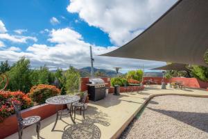 un patio con mesas, sillas y una parrilla en Eagle View Escape, en Rydal