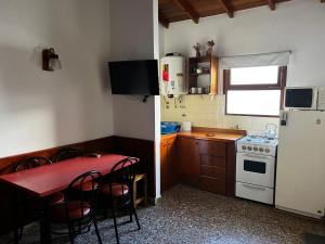 una piccola cucina con tavolo e frigorifero di PH a 1 cuadra de la playa, 2 amb, patio y parrilla a Villa Gesell