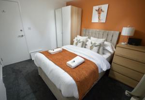 コベントリーにあるGF Apartment sleeps5 near Coventry City Centre with FREE SECURE gated parkingのベッドルーム1室(大型ベッド1台、タオル2枚付)