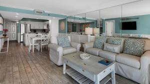 a living room with two couches and a kitchen at Beachcrest 604 in Seagrove Beach