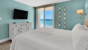 a bedroom with a bed and a television and a balcony at Beachcrest 604 in Seagrove Beach +43 photos