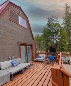 eine Holzterrasse mit Hängematte und ein Haus in der Unterkunft Charming Blue Farmhouse Cabin in Duck Creek Village