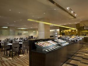 un restaurante con una línea de buffet con mesas y sillas en Celebrity International Grand Hotel, en Beijing