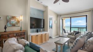 Beachside Condo 11 في شاطئ سانتا روزا: غرفة معيشة مع أريكة وتلفزيون بشاشة مسطحة