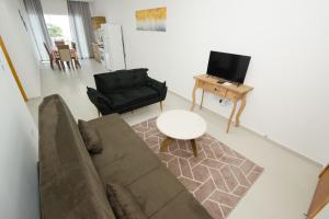 uma sala de estar com um sofá e uma mesa em Apartamentos Sinhá em Penha