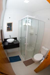 a bathroom with a shower and a toilet and a sink at Apartamentos Sinhá in Penha +22 photos
