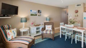 Beachside Condo 14 في شاطئ سانتا روزا: غرفة معيشة مع طاولة وكراسي وتلفزيون