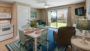 Beachside Condo 14 في شاطئ سانتا روزا: مطبخ وغرفة طعام مع طاولة وكراسي