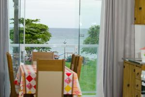 uma cozinha com uma mesa e vista para o oceano em Apartamentos Sinhá em Penha