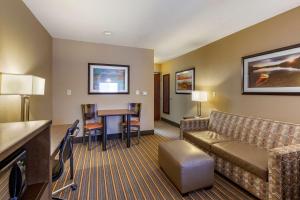 a hotel room with a couch and a table at Best Western Plus Woodstock Inn & Suites in Woodstock