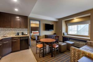 a kitchen with a table and a room with a bed at Best Western Plus Woodstock Inn & Suites in Woodstock