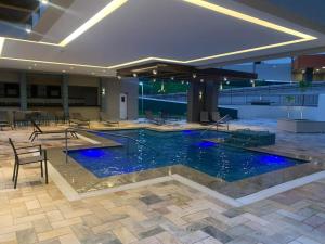 a large pool with blue lights in a building at Apartamento no Solar das Águas Resort em Olímpia - SP in Olímpia