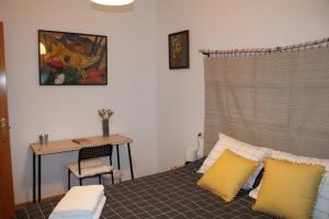 sypialnia z biurkiem i łóżkiem z żółtymi poduszkami w obiekcie La casa de los abedules w mieście León