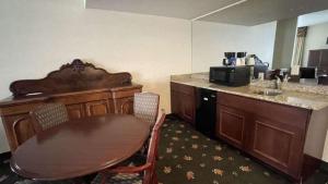 Zimmer mit einem Tisch und einer Küche mit einem Waschbecken in der Unterkunft SureStay Hotel by Best Western Eureka in Eureka