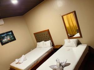 dwa łóżka w małym pokoju z lustrem w obiekcie HOSTAL VS w mieście Iquitos