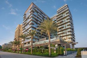 a tall building with palm trees in front of it at Radisson Beach Resort Palm Jumeirah in Dubai