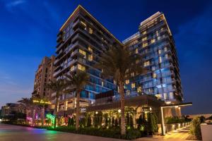 a tall building with palm trees in front of it at Radisson Beach Resort Palm Jumeirah in Dubai