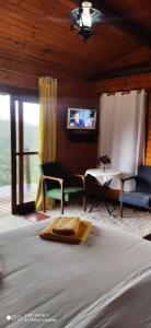 ヴィスコンデ・デ・マウアーにあるCabana Vista Maravilhosaのベッドルーム1室(ベッド1台、ソファ、テーブル付)