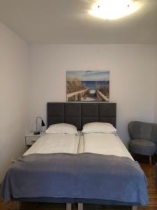 1 dormitorio con 1 cama y una pintura en la pared en Villa Ola, en Polanica-Zdrój