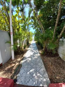 una pasarela con palmeras al lado de una carretera en Apartamento Balneário Piçarras en Piçarras