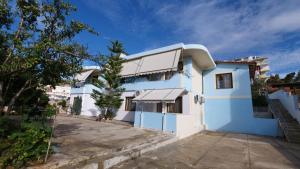 a blue and white house with a driveway at Kiri S.Apartaments in Sarandë