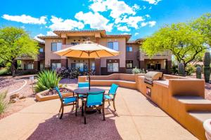 un patio avec une table, des chaises et un parasol dans l'établissement Vistoso Resort Casita #105, à Oro Valley