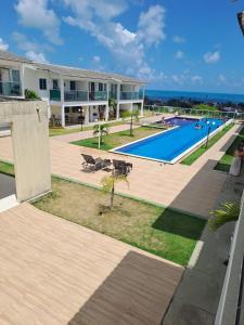 a large apartment building with a swimming pool at Bangalô/Dúplex Jacumã Conde in Jacumã