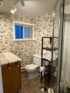 La salle de bains est pourvue de toilettes, d'un lavabo et d'une fenêtre. dans l'établissement Parlor Suite in Heritage Manor, Fairfield, near DT, à Victoria