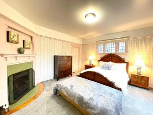 1 dormitorio con 1 cama grande y chimenea en Parlor Suite in Heritage Manor, Fairfield, near DT, en Victoria
