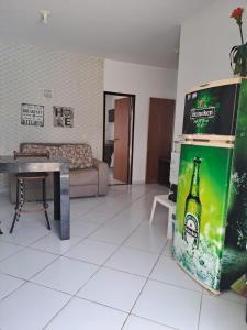 a living room with a bottle of beer in a refrigerator at Apartamento/Flat em Jacumã in Conde