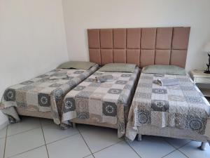 two beds sitting next to each other in a room at Apartamento/Flat em Jacumã in Conde