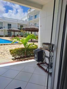 a balcony with a tv and a pool at Apartamento/Flat em Jacumã in Conde