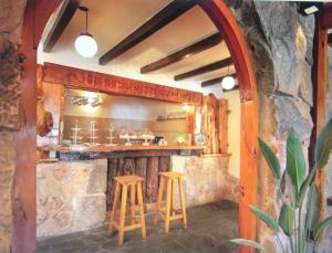 un bar con dos taburetes y una pared de piedra en Cabañas Aufenthalt en Villa General Belgrano