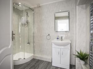 a bathroom with a shower and a sink and a tub at Bryn Llifon in Pentraeth