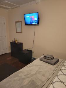 a bedroom with a bed and a flat screen tv on the wall at Large Spacious Bedroom with Private Entrance Females Only in Westwego