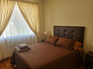 um quarto com uma cama e uma janela grande em EL OLMO em La Paz