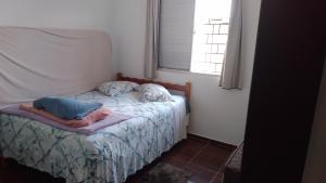 uma pequena cama num quarto com uma janela em Brisa do Mar Guaratuba em Guaratuba