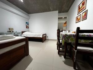 a room with two beds and a table and chairs at LAJUACA in San Salvador de Jujuy