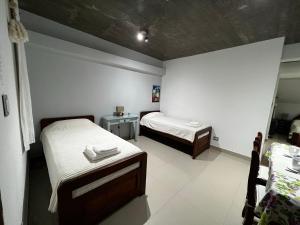 Kleines Zimmer mit 2 Betten und einem Tisch in der Unterkunft LAJUACA in San Salvador de Jujuy
