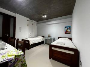 a small room with two beds and a table at LAJUACA in San Salvador de Jujuy