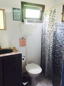 a bathroom with a toilet and a sink and a shower at Praia do Rosa Hostel in Praia do Rosa