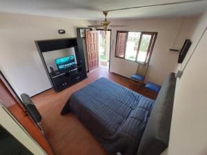1 dormitorio con 1 cama y TV de pantalla plana en DEPARTAMENTO PRIVADO CON PILETA en Villa Carlos Paz