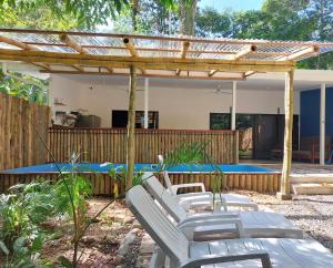 a patio with white chairs and a swimming pool at Brand new huge apt with Air Conditioner and a private pool and kitchen in Cocles