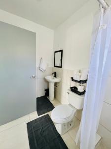 a white bathroom with a toilet and a sink at SALT ST LUCIA in Vieux Fort