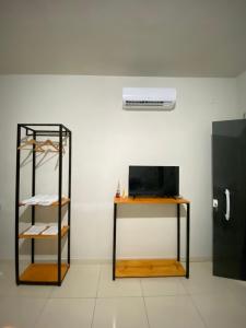 une chambre avec une étagère et une télévision sur une table dans l'établissement FLATS VALLE DEL SOL, à Japaratinga