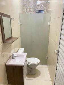 y baño con aseo, lavabo y espejo. en FLATS VALLE DEL SOL en Japaratinga