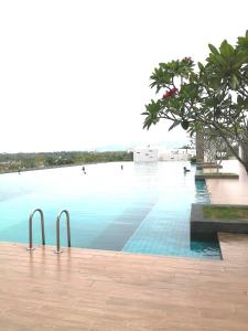 une piscine d'eau bleue et un arbre dans l'établissement NiDaHomeStay Nilai USIM KLIA WiFi androidtv full aircond, à Nilai