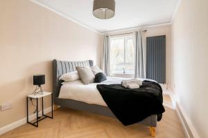 1 dormitorio con cama y ventana en Riverside serviced apartments, en Londres
