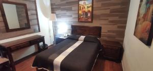 a bedroom with a bed and a table and a mirror at Hotel La Posta in Monclova