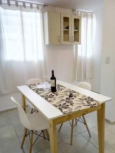 una mesa de comedor con una botella de vino. en Céntrico departamento en Godoy Cruz, Mendoza en Godoy Cruz